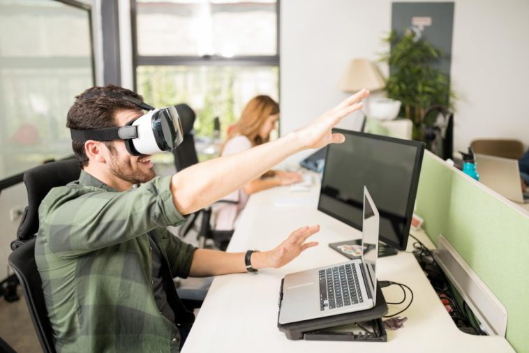 Entrepreneur using VR goggles at his tech startup