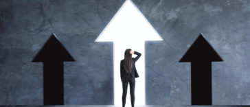 businessperson looking at arrows pointing upward growth concept