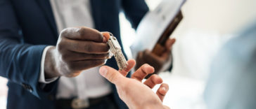 Real estate agent handing the house key to a client