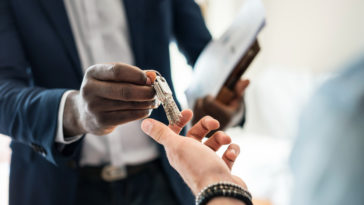 Real estate agent handing the house key to a client