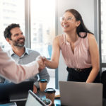 businesswoman shaking hands with colleague during an office meeting