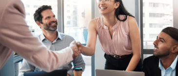 businesswoman shaking hands with colleague during an office meeting