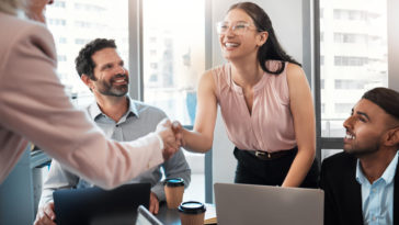 businesswoman shaking hands with colleague during an office meeting