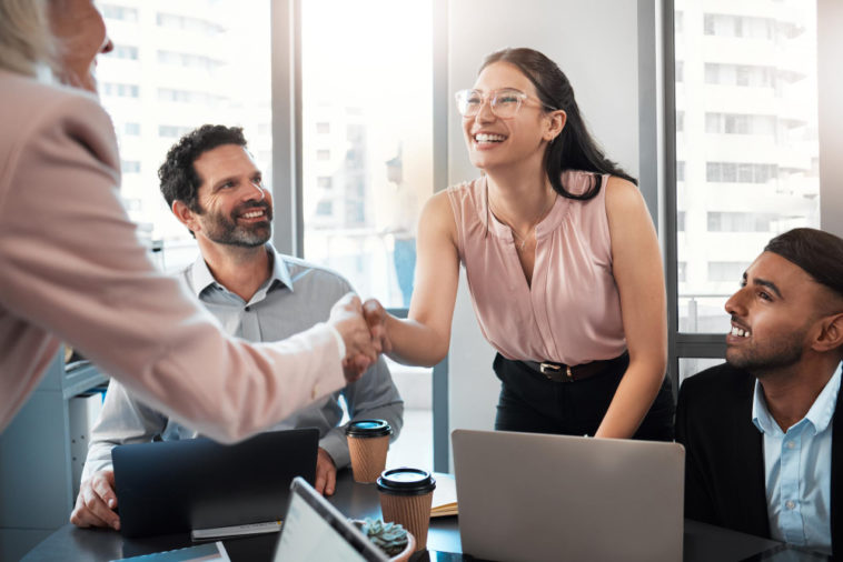 businesswoman shaking hands with colleague during an office meeting