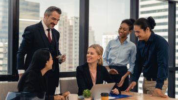 group of people in an office having a business meeting and smiling