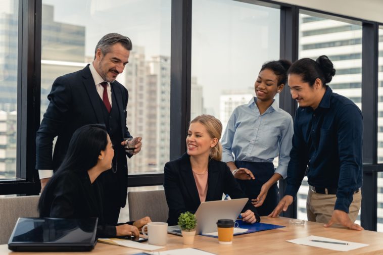 group of people in an office having a business meeting and smiling