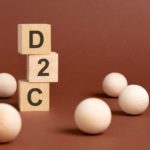 wooden cubes with d2c text on them and a brown background