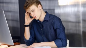 young businessman looking stressed in an office
