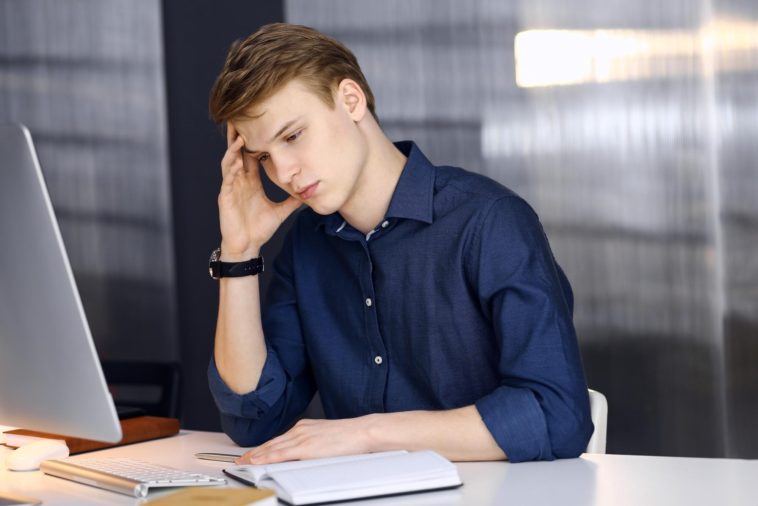 young businessman looking stressed in an office