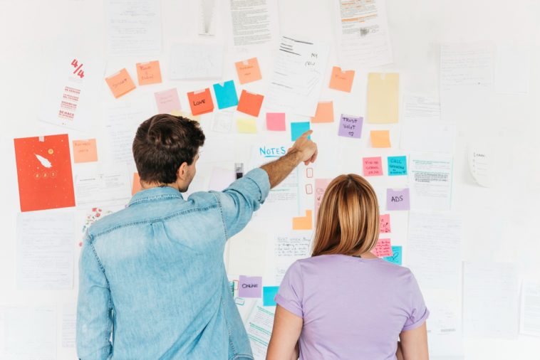 young employees looking at a wall with marketing notes